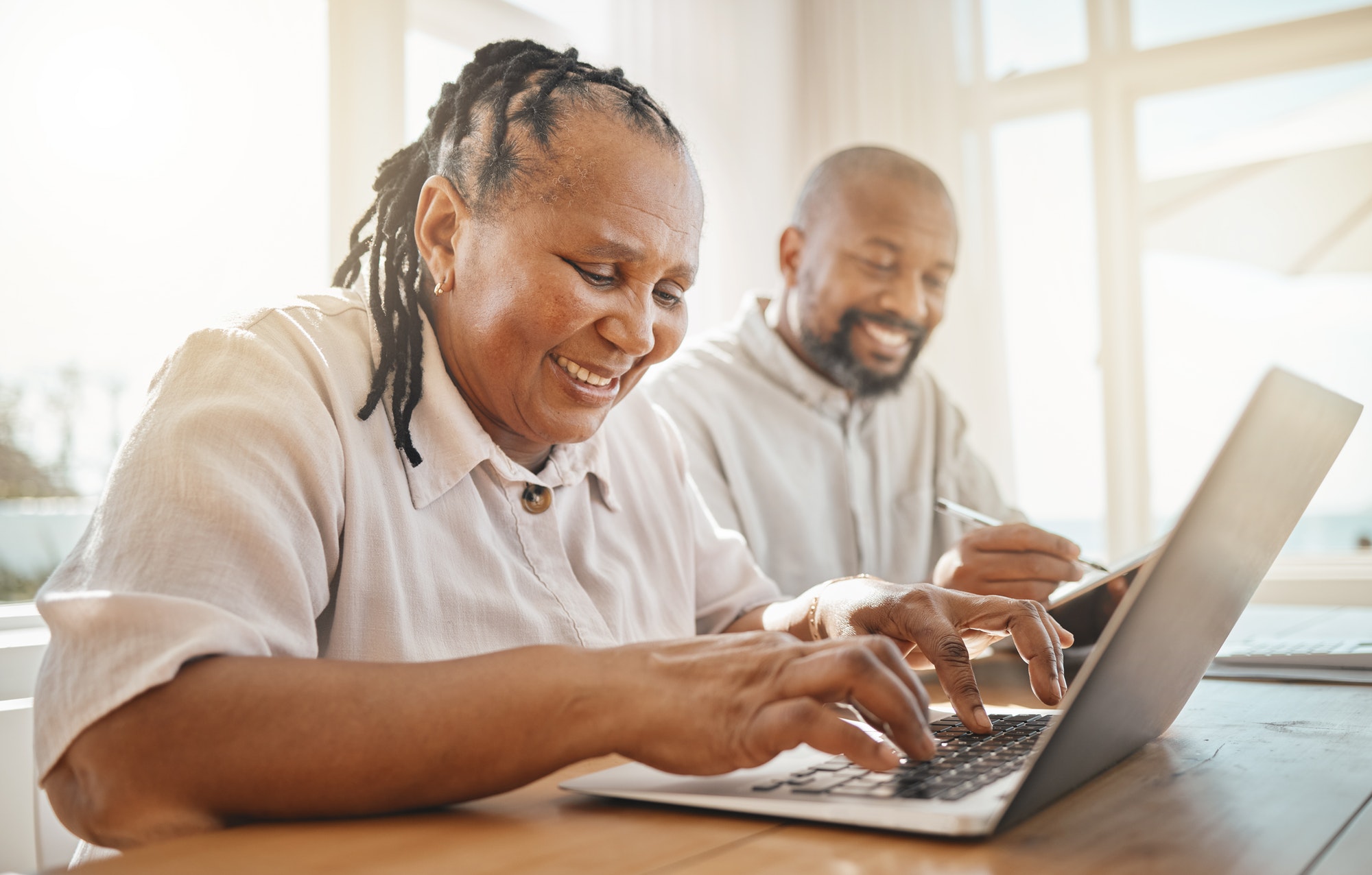 Love, senior couple and budget in lounge, retirement and laptop with fintech, discussion and planni
